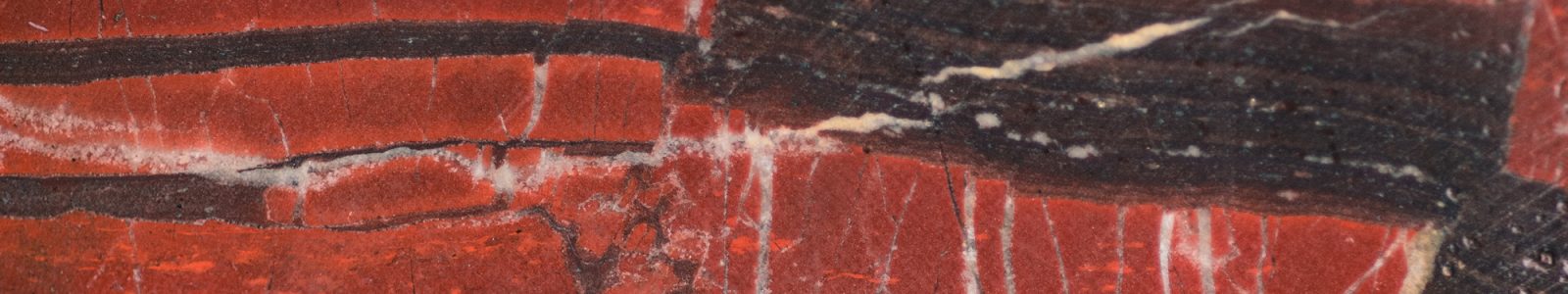 Rock sample from the Barberton core showing a closeup of orange and dark red striations